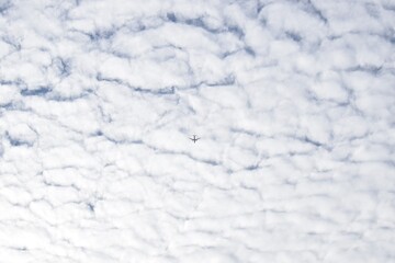 Airplane, white clouds and the blue sky. Fluffy nature 
