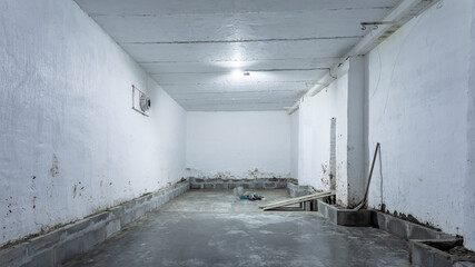 The interior of a huge industrial warehouse made of white bricks with a high ceiling for storing goods. 