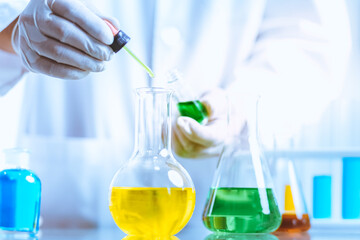 Hand of Biochemical research scientist working with science laboratory test tubes for coronavirus vaccine development in pharmaceutical research labolatory.