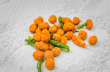 Closeup Shot of a Bunch of Deep Fried Spicy Masala Peanuts along with Fried Curry Leaves and Garlic on a white cloth