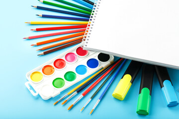 A set of school supplies for learning and creative development on a blue background.