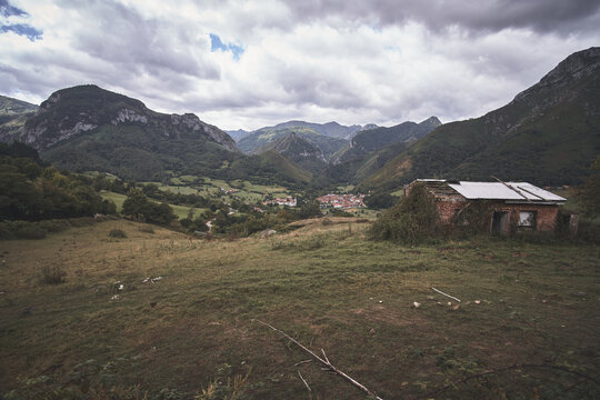 Old abandoned shack at a valley under  a cloudy sky in Soto de Agues, Asturias, Spain