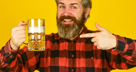 strong drink in supermarket. Beer with foam. brutal hipster drink beer. mature bearded barman hold beer glass. confident bartender raising toast. leisure and celebration. Man drinking beer in pub bar