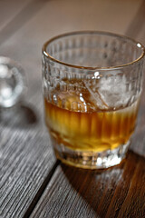Whisky, bourbon or cognac in glass with ice ball and  crystal bung on wooden table. Alcohol drink background