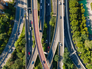 Drone aerial view of curved overpass multi lane highways in daytime summer. Travel tourism and city life transportation concept footage. Trees and green plant around the highway in Shanghai China.
