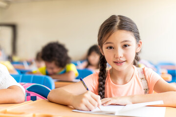 beautiful little girl  studying in the classroom.