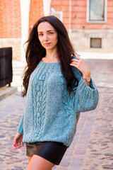 Woman in green handmade knitted sweater posing in the old city
