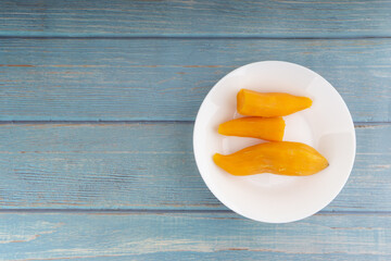 Ubi rebus or steam cassava is traditional malay dish on wooden background. Selective focus