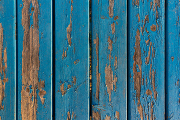 texture close up of blue paint peeling from wooden planks