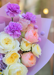 Flower shop. Beautiful bouquet of mixed flowers in man's hands. The work of the florist at a flower shop. Delicate bright color. Fresh cut flower.