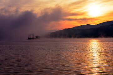 Naklejka premium 아침노을에 물든 물안개와 섬