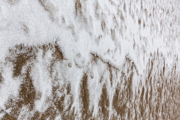 Abstract shapes with sand dunes covered by fresh powder snow, in a wild river bed, in winter