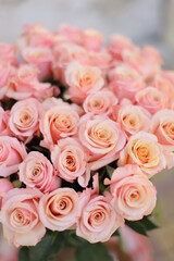 Fototapeta na wymiar Beautiful flower bouquet of peach rose. Big bouquet of roses in vase on table.