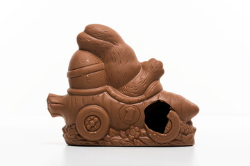 Chocolate bunny driving a car with broken wheel. Funny sweet Easter chocolate for children