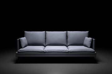 Grey couch with pillows on studio black background.
