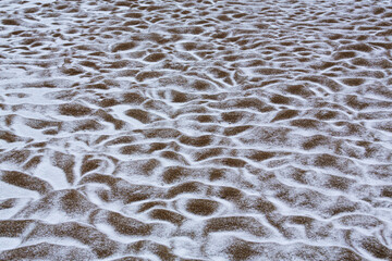 Abstract shapes with sand dunes covered by fresh powder snow, in a wild river bed, in winter