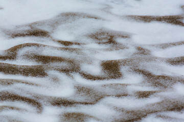 Abstract shapes with sand dunes covered by fresh powder snow, in a wild river bed, in winter