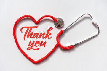 Stethoscope forming heart with its cord. Thank you doctor and Nurses and medical personnel team. Healthcare concept. Space for text. Soft focus. Top view.