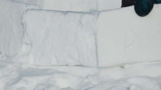 Igloo. Team members build a Igloo out of snow blocks and level them with a hacksaw. Novosibirsk, Russia / Siberia, February / 15 / 2020, annual holiday "Eskimo city". Close up.