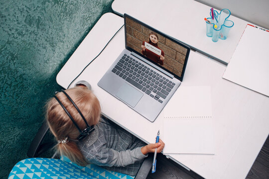 Young student little girl with tacher holds white poster in hands on laptop screen learning and preparing back to school
