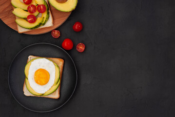 Healthy brekfast toasts with avocado on the black stone background flat lay mock-up with copy space