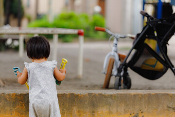 砂場で遊ぶ幼児の後ろ姿