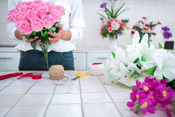 Arranging artificial flowers decoration at home, Young woman florist work making organizing diy artificial flower, craft and hand made concept