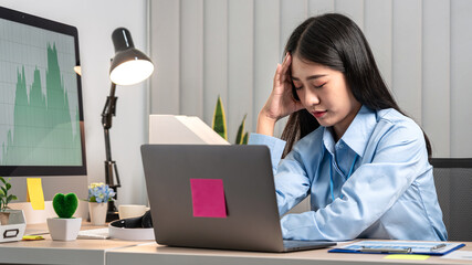 Portrait of young asian business woman feeling stress and tired from work sitting on the chair about constant headaches a migraine of working hard at office