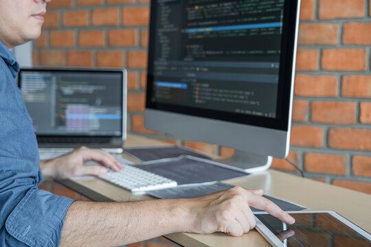 Young Professional programmer working at developing programming and website working in a software develop company office, writing codes and typing data code, Programming with HTML, PHP and javascript