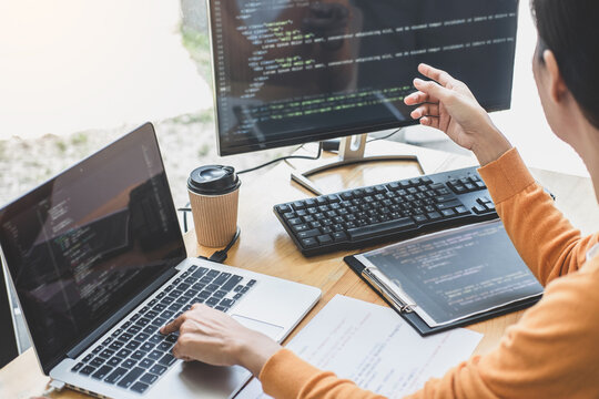 Young Professional programmer working at developing programming and website working in a software develop company office, writing codes and typing data code, Programming with HTML, PHP and javascript