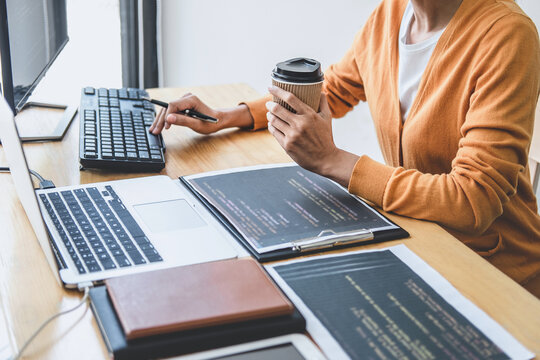 Young Professional programmer working at developing programming and website working in a software develop company office, writing codes and typing data code, Programming with HTML, PHP and javascript