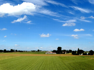 Fototapeta na wymiar Landscape of farm and house in field in summer season in Eastern Europe.