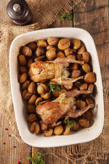 baked quail with chestnut on wood background