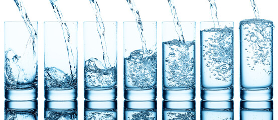Pouring water into glass isolated on  white.