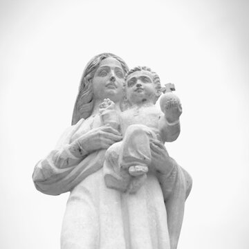 Ancient statue of the Virgin Mary with Jesus Christ. Religion, faith, love, Christianity concept. Black and white image.