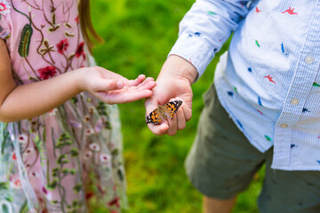 Kids playing with a butterfly in the garden