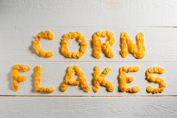 Words made from cornflakes laid out on a white wooden table.