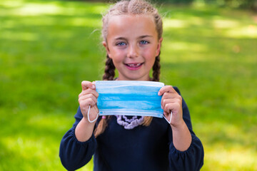 Schoolgirl holding a face mask