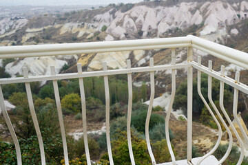 Fence with landscape of Cappadocia, semi-arid region in central Turkey known for distinctive fairy chimneys, tall cone-shaped rock formations clustered in Monks Valley, Göreme and elsewhere- Kayseri