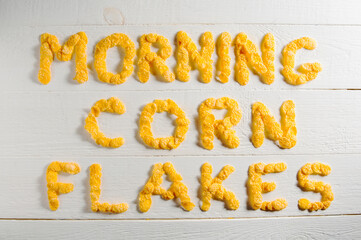 Words made from cornflakes laid out on a white wooden table.