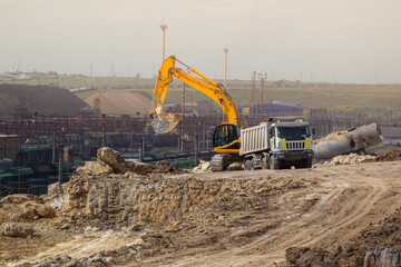 Crawler excavator perform earthworks for loading soil into a dump truck