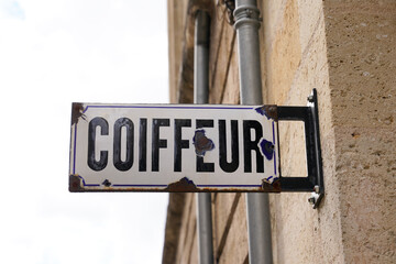 Coiffeur french text sign of classic vintage hairdresser shop in the street