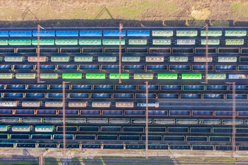 Railway station with freight wagons, hapras with unfilled cargo: coal, ore and grain. View from above.