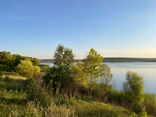 Landscape. Looking at the horizon by the river in early autumn. Nature by the lake at sunset. Mobile photography, horizontal.