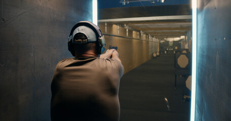 Anonymous man shooting pistol at target