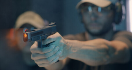 Middle aged shooter firing pistol
