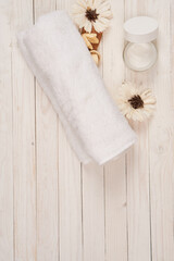 Obraz na płótnie Canvas White towel cosmetics bathroom accessories wooden background scenery