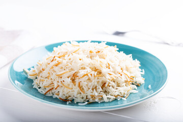 Cooked basmati rice served in a ceramic bowl or plate on white background.