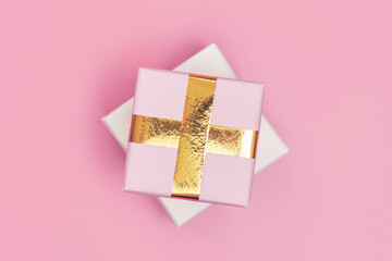 christmas gift with gold ribbon on pink background isolate, copy space, layout