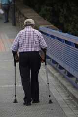 Man walking helped by crutches